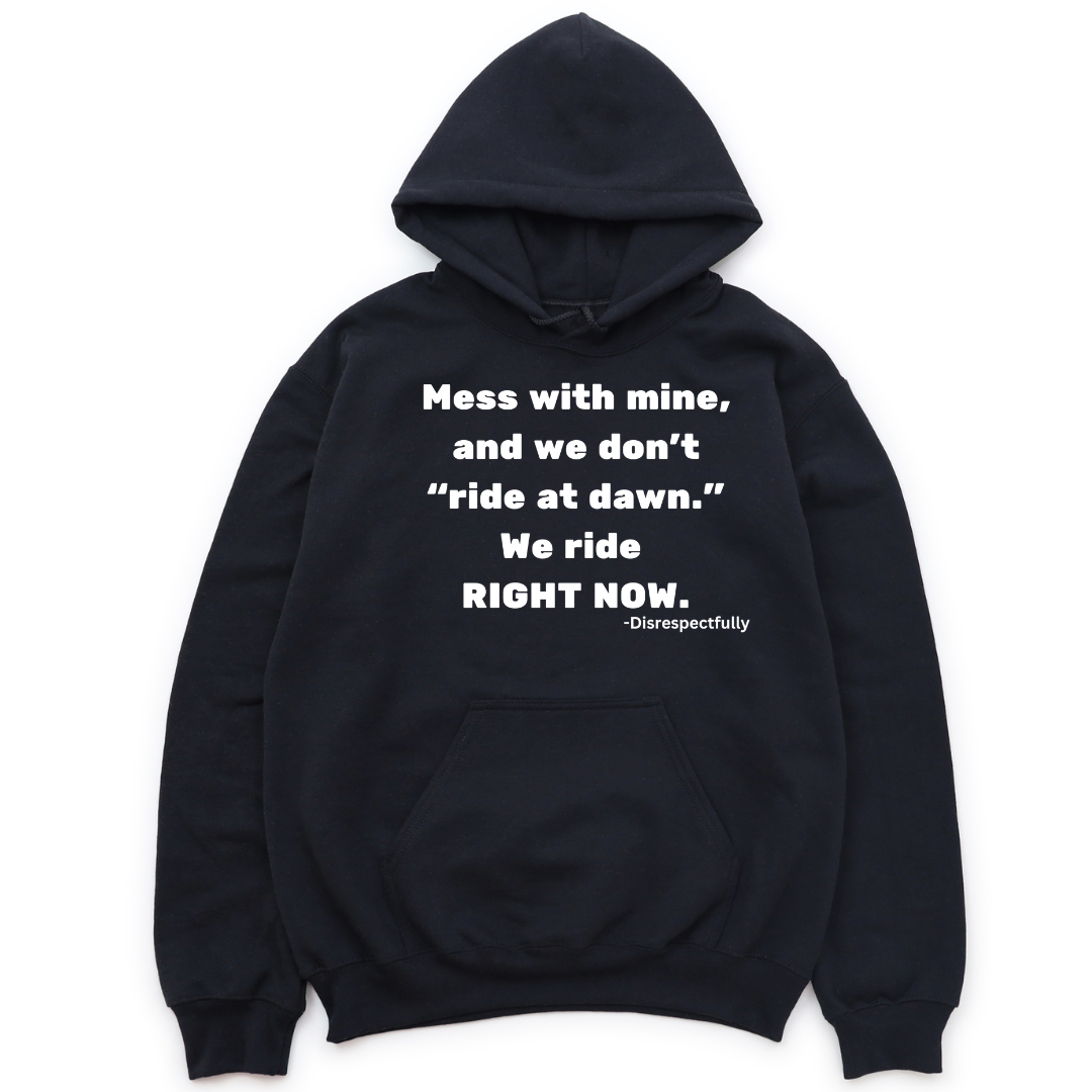 Black unisex hoodie with the bold slogan ‘Mess With Mine and We Don’t Ride at Dawn, We Ride Right Now,’ celebrating loyalty and melanin pride.
